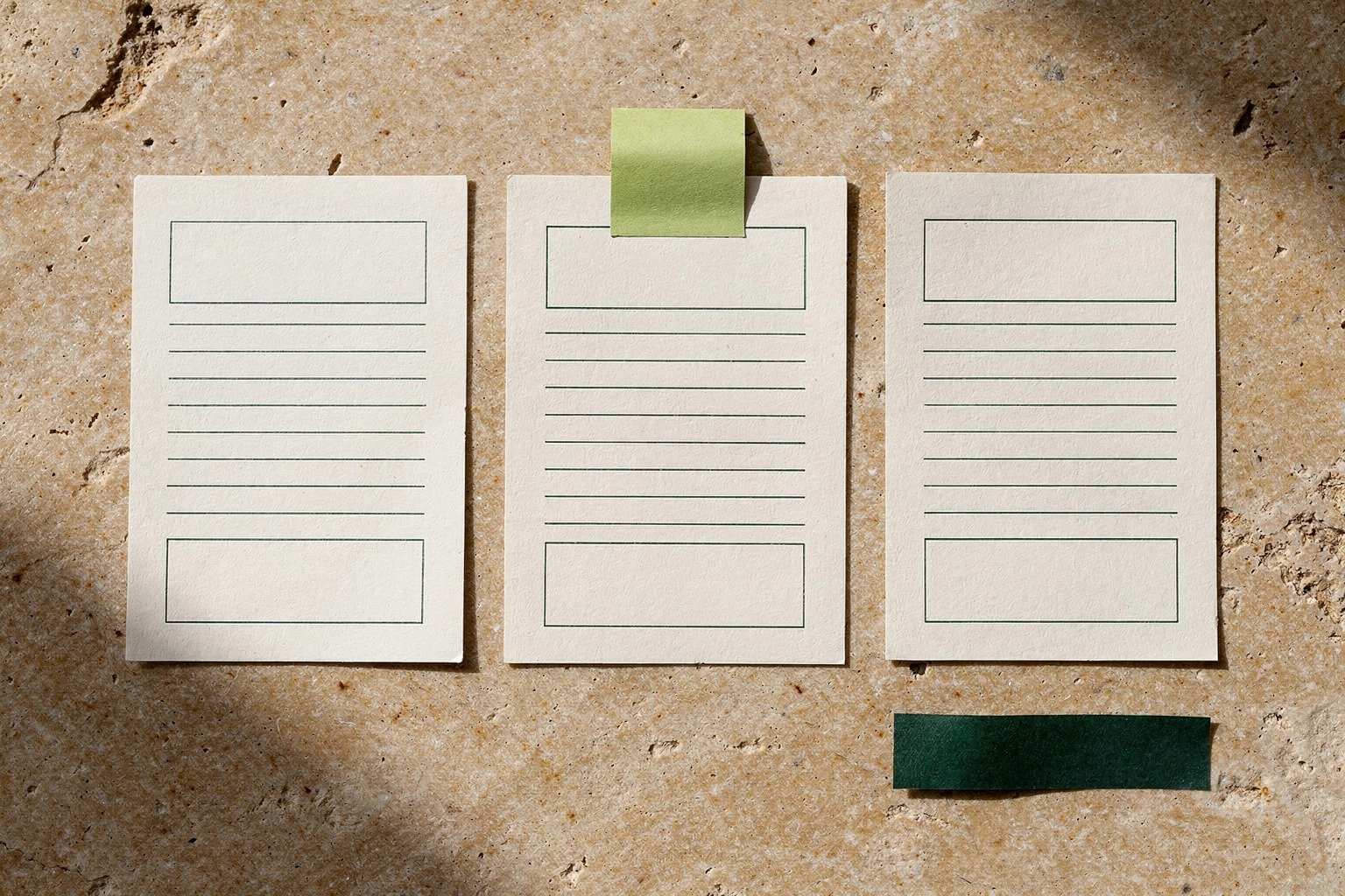 Generated concept image of cream proof cards arranged on a stone surface with green tape accents.